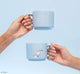 Hands holding FarmHouse Fresh Smurfy Day To Save Ceramic Mugs. All profits help rescue animals.