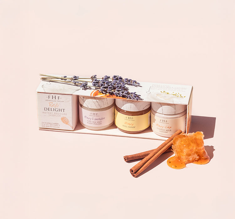 A box with three jars from Pedi Delight Instant Pedicure Sampler by FarmHouse Fresh. The set contains salt scrub, Honey Heel Glaze and a body lotion.