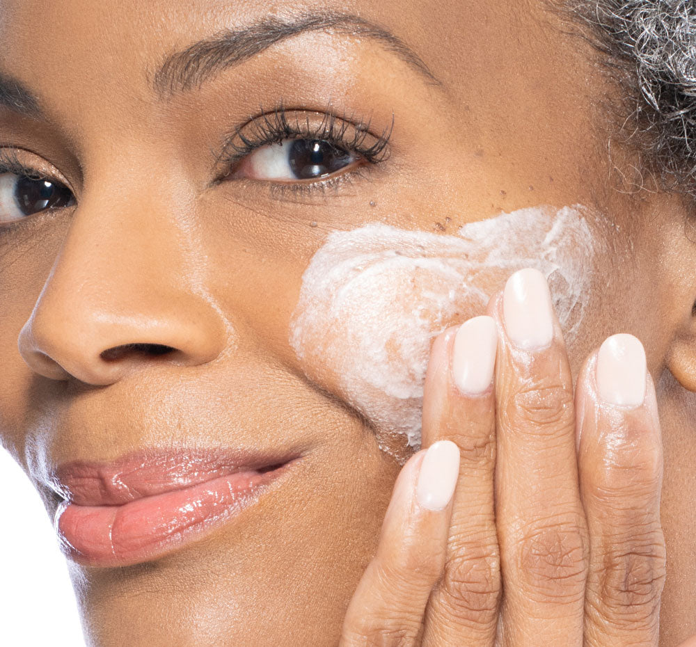 Woman applying Three Milk Whipfoliant to sweep away dead skin