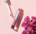 A tube of FarmHouse Fresh Vitamin Glaze Oil Infused Lip Gloss in Violet Orchidcolor.