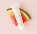 A tube of FarmHouse Fresh Blissed Moon Dip Back To Youth Ageless Mousse for Hands on top of a watermelon slice.