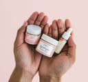 Person’s hands holding three samples of FarmHouse Fresh facial skincare products.