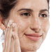 A woman is exfoliating her face with Farmhouse Fresh Finely Awake daily exfoliating cleanser that brings refreshed feel.