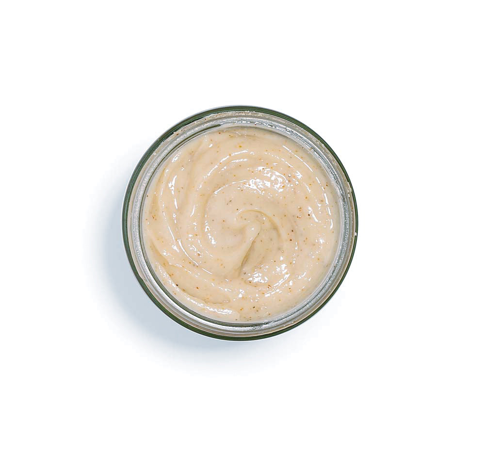 Top view of an opened jar of Finely Awake Plantfoliant Silkening Face Cleansing Polish by FarmHouse Fresh showing its grainy, exfoliating texture.