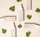 Bottles of FarmHouse Fresh Hyaluronic Boosters next to parsley leaves that represent the natural antioxidant-rich ingredients.