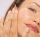 A woman is showing her plump complexion after using FarmHouse Fresh Hyaluronic Booster.
