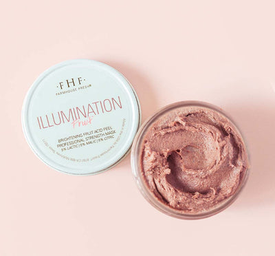 An opened jar of Illumination Fruit Professional Strength Brightening Fruit Acid Peel Mask by FarmHouse Fresh on a pink background.