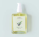 A bottle of Juniper Ale body oil by FarmHouse Fresh scented with fresh greens and bergamot orange.