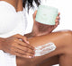 A woman is exfoliating her leg with FarmHouse Fresh Lime So Fine Foaming Body Polish to achieve silky smooth skin.