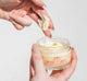 Woman’s hands scooping FarmHouse Fresh Make It Melt Silky Milk Cleansing Balm out of a jar, showing its rich, silky texture that removes makeup and remaining dirt and pore-clogging oils.