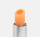 The top of an open tube of FarmHouse Fresh Orange Mood Fruit tinted lip balm that nourishes and soothes dry lips.