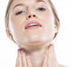 A woman applying FarmHouse Fresh Serene Moon Dip Body Mousse for aging skin on her neck to smooth the look of wrinkles.