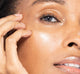 A woman with FarmHouse Fresh Pink Dusk Illuminating Peptide Serum applied to her face, demonstrating her dewy skin with luminous finish.