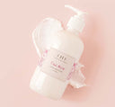 A bottle of FarmHouse Fresh Pink Moon Shea Butter body moisturizer scented with notes of spun sugar and licorice.