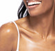 A woman with FarmHouse Fresh Sunshine Silk Shimmer Air Oil applied to her skin, showing the natural, beautiful glow and soft, supple skin.