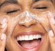 A woman exfoliating her face with FarmHouse Fresh Timescape Renewing Face Polish that delivers a smooth, glowing skin.