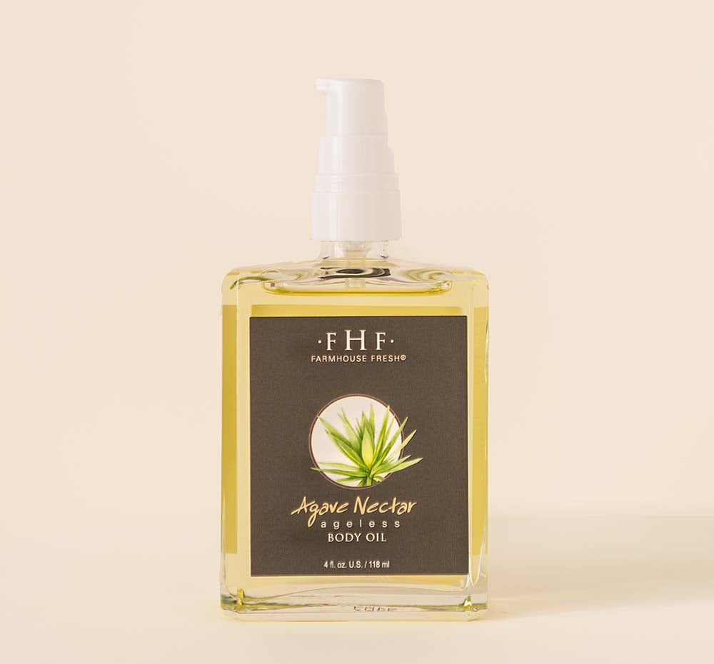 A bottle of FarmHouse Fresh Agave Nectar Ageless Body Oil with agave plant.