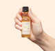 Hand holding FarmHouse Fresh Vanilla Bourbon body oil Deluxe Sample that moisturizes and bring glow to skin.