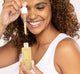 A woman is holding a bottle of FarmHouse Fresh Bakuchiol Booster serum that leaves skin glowing, soft and silky.