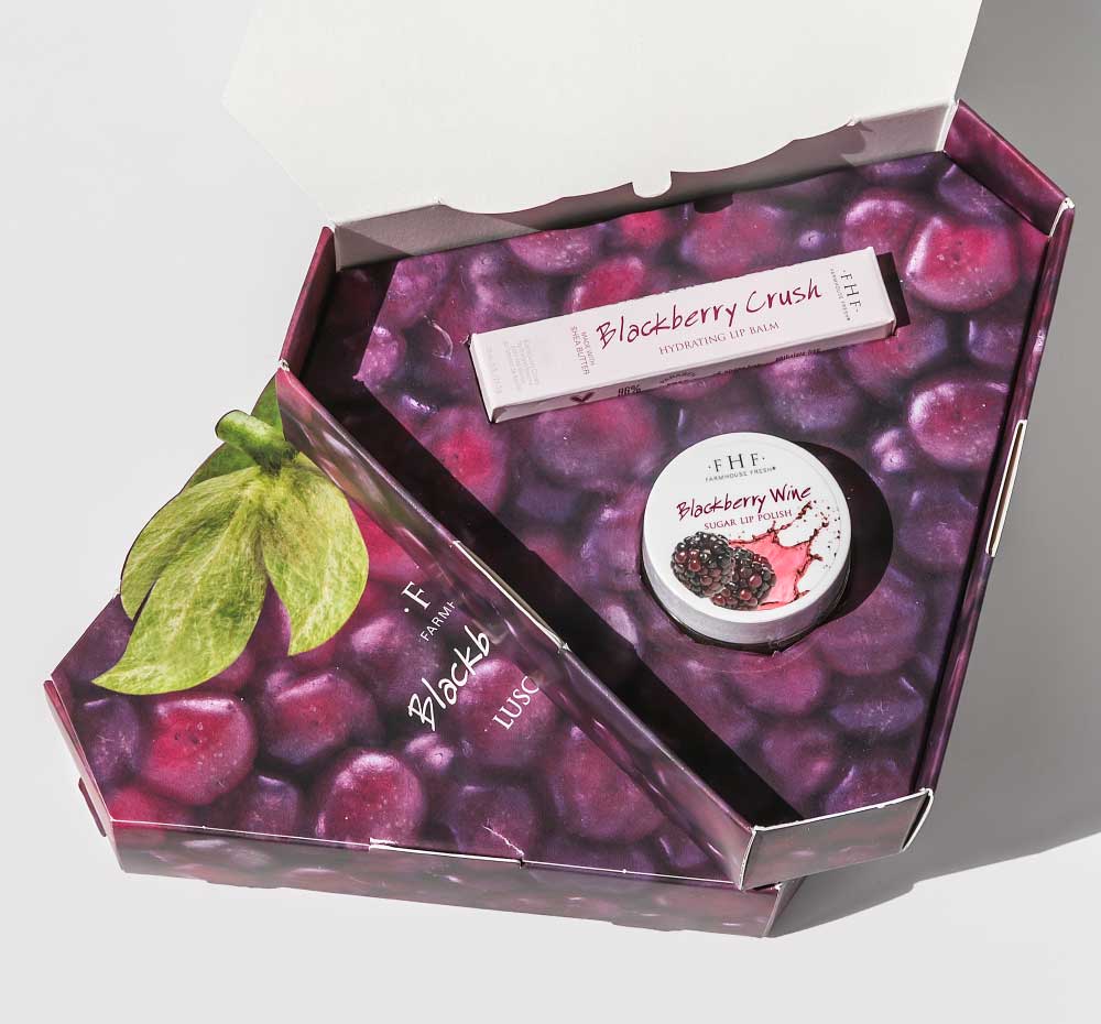 FarmHouse Fresh Blackberry Crush Lip Kit that includes a lip polish and lip balm made with organic blackberries, housed in a blackberry-shaped gift box.