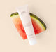 A tube of FarmHouse Fresh Blissed Moon Dip Back To Youth Ageless Mousse for Hands on top of a watermelon slice.