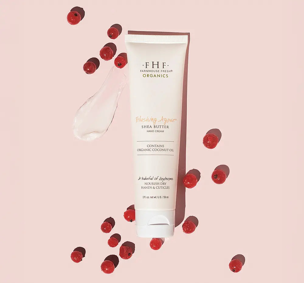 Blushing Agave Shea Butter Hand Cream tube with red berries on a pink background