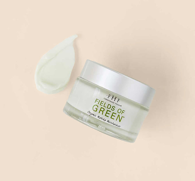 A jar and a texture smear of FarmHouse Fresh Fields of Green Organic Matcha Ultra-Soothing Face Moisturizer that hydrates, soothes and rejuvenates skin.