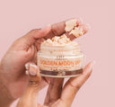 A woman dipping her fingers into a jar of FarmHouse Fresh Golden Moon Dip Illumination Mousse with Retinol and Wrinkle-Targeting Peptides.