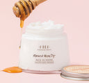 A honey stick next to a jar of FarmHouse Fresh Harvest Moon Dip Ageless Body Mousse made with age-fighting ingredients like firming peptides & retinol.