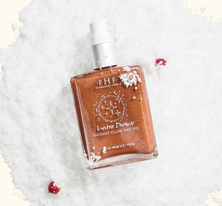 FarmHouse Fresh Lustre Drench Instant Glow Dry Oil Body Spray styled with festive holiday greenery and red berries