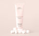 A tube of FarmHouse Fresh’s nourishing Marshmallow Melt Shea Butter for hands for dry skin with marshmallows next to it.