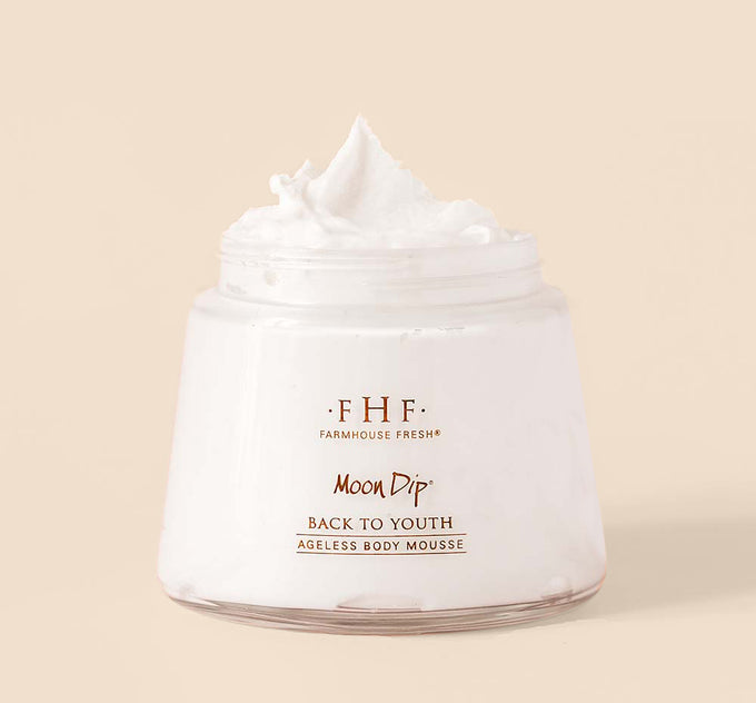 An opened jar of FarmHouse Fresh Moon Dip Ageless Body Mousse made with age-fighting ingredients like firming peptides & retinol.