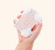 
A hand holding a bar of softly scented FarmHouse Fresh Pink Moon Shea Butter Bar Soap with rich lather on it.
