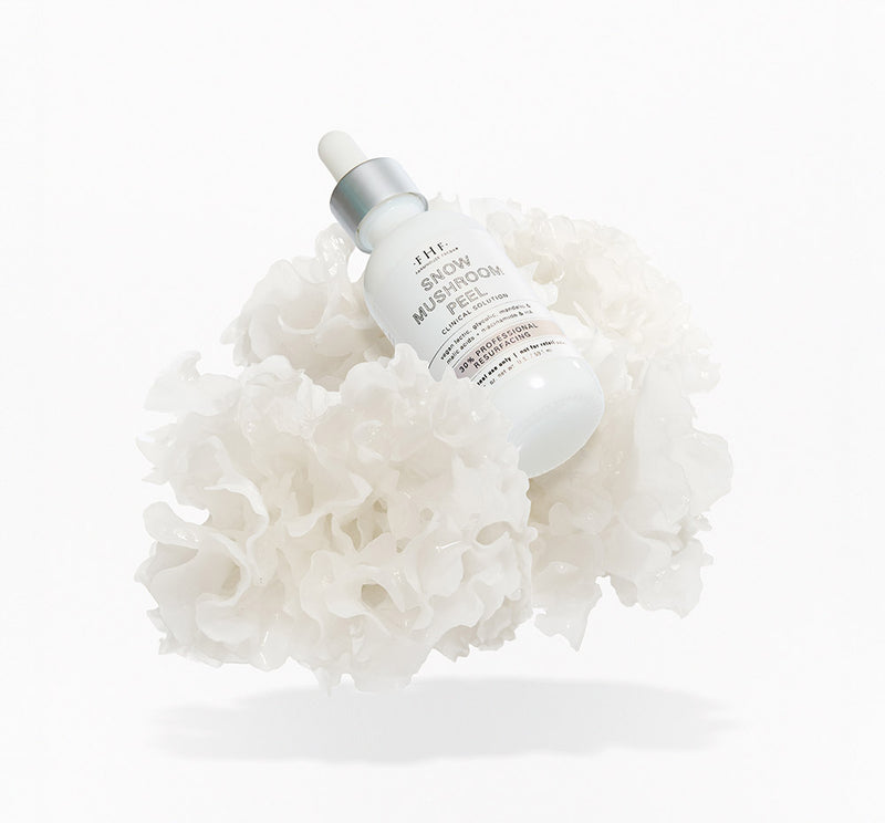 FHF Snow Mushroom Peel bottle sitting on a floating snow mushroom, on a white background.