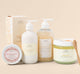 A set of Rainbow Bubbletini body care products by Farmhouse Fresh, including body polish, body wash, shea butter body lotion and a body balm.