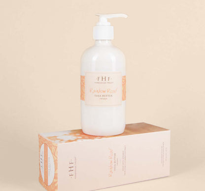 A bottle on top of a box of moisturizing Rainbow Road Shea Butter for body by Farmhouse Fresh with an uplifting scent of pear and coconut.