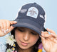 A woman wearing FarmHouse Fresh Smurfin' Cool Trucker Hat to show off her passion for saving animals.