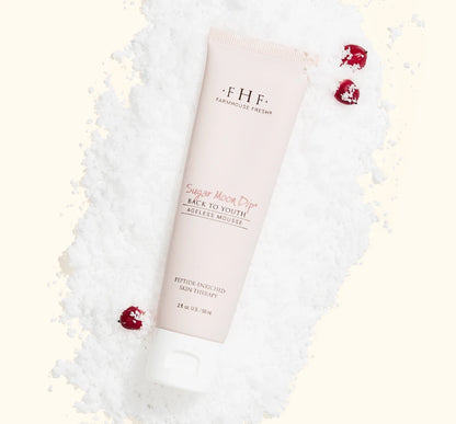 FarmHouse Fresh Sugar Moon Dip Back to Youth Ageless Hand Cream styled with festive holiday greenery and red berries