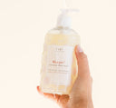 A hand holding FarmHouse Fresh Whoopie Soothing Body Wash made with skin calming botanical extracts like green tea and chamomile.