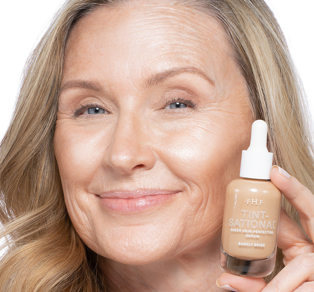 Tint-sational Sheer Skin-Perfecting Serum applied on woman holding bottle of shade Barely Beige