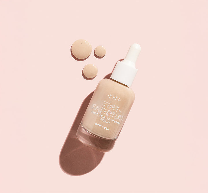 Tint-sational™ Sheer Skin-Perfecting Serum bottle in shade Ivory Veil with product droplets