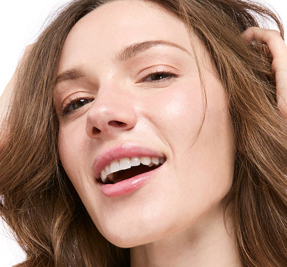 Close up of woman's smiling face wearing Tint-sational Sheer Skin-Perfecting Serum using shade Ivory Veil