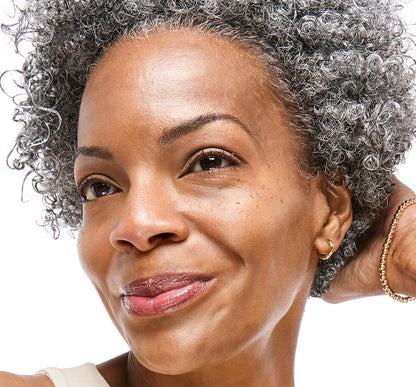 Close up of woman's smiling face wearing Tint-sational Sheer Skin-Perfecting Serum using shade Rich Cocoa