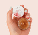 A hand holding natural and gentle Whoopie Lip Polish by Farmhouse Fresh.