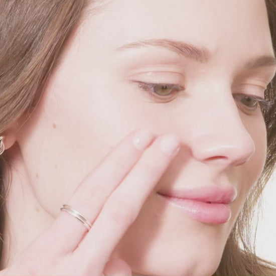 woman's face swiping Tint-sational serum and blending into skin