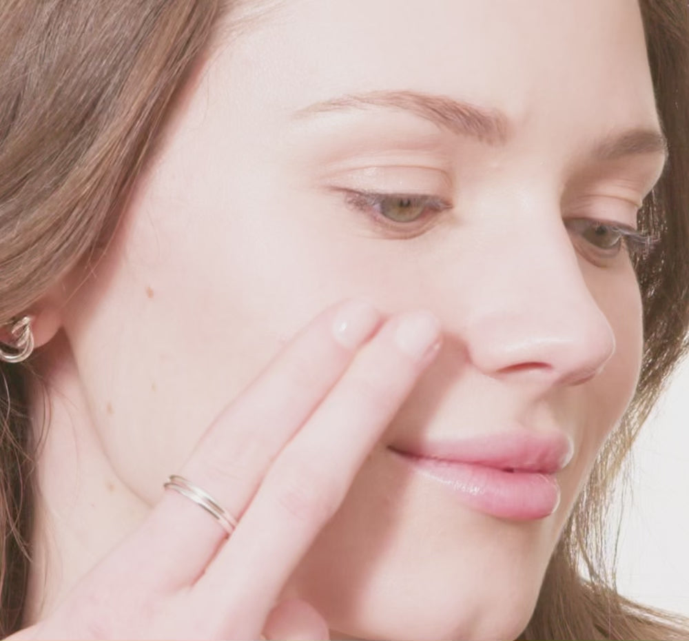 woman's face swiping Tint-sational serum and blending into skin