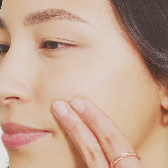 woman's face swiping Tint-sational serum and blending into skin