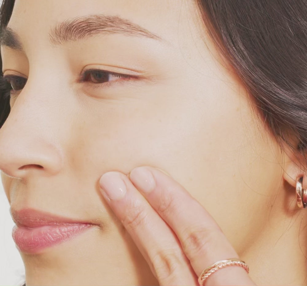 woman's face swiping Tint-sational serum and blending into skin