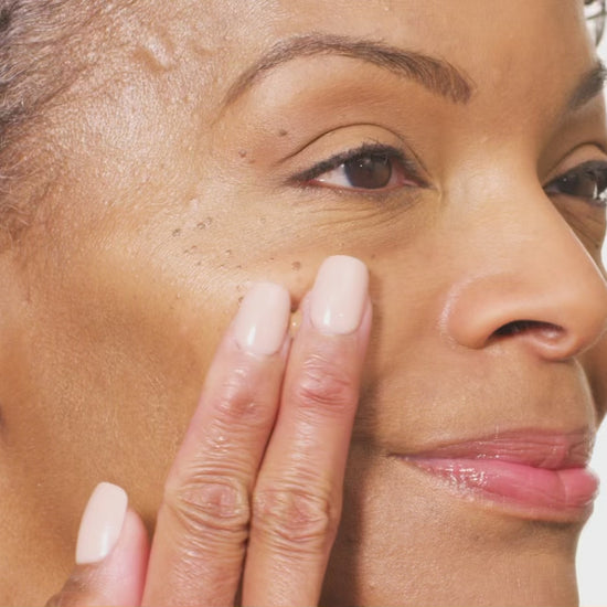 woman's face swiping Tint-sational serum and blending into skin