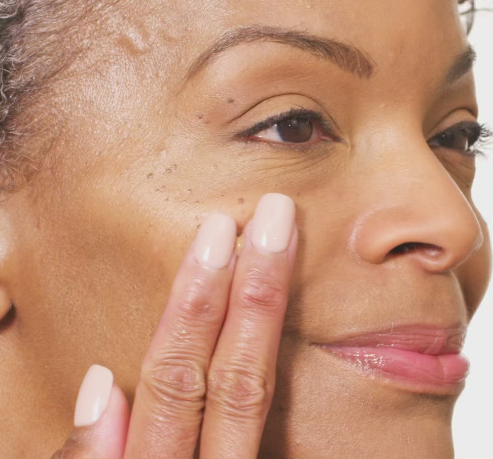 woman's face swiping Tint-sational serum and blending into skin